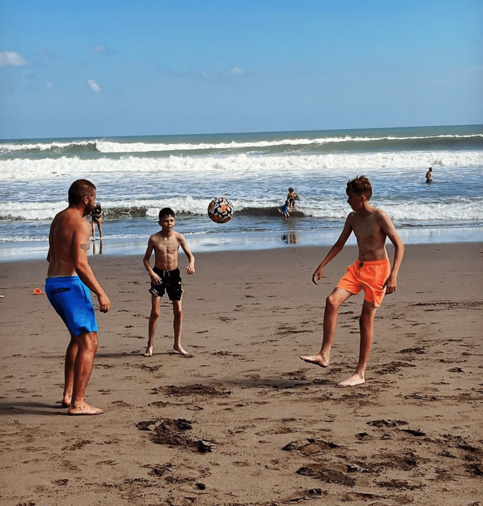 Norwegain family playing soccer on the beach in Bali